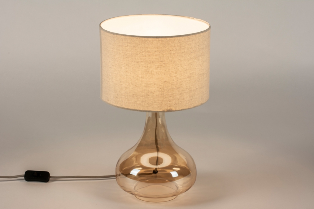Foto 15301: Vaaslamp van amberkleurig glas met een beige linnen kap 