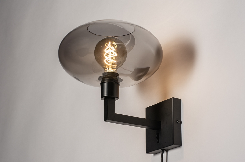 Foto 31040: Moderne, mat zwarte wandlamp voorzien van een rookglazen kap, geschikt voor led verlichting.