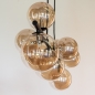 Foto 15253-20: Langwerpige hanglamp in het zwart met negen bollen van glas in amber kleur