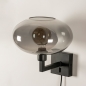 Foto 31017-23 schuinaanzicht: Moderne zwarte wandlamp voorzien van een rookglazen kap, geschikt voor led verlichting.