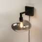Foto 31040-13 schuinaanzicht: Moderne, mat zwarte wandlamp voorzien van een rookglazen kap, geschikt voor led verlichting.