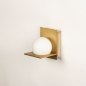 Foto 74930-6 schuinaanzicht: Art deco wandlamp in messing/goud met witte bol van glas